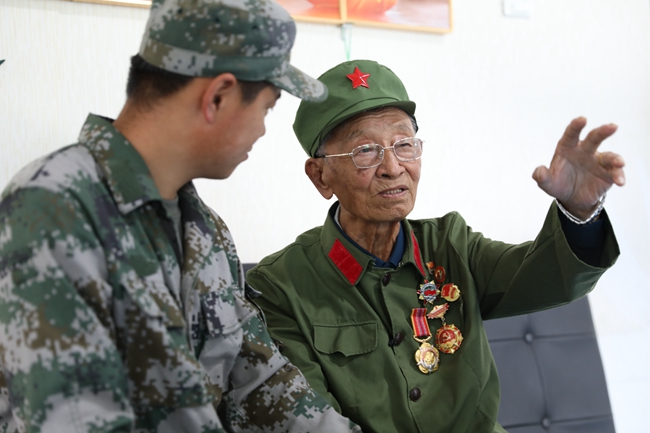 老兵王振余為青年人講述自己的戰(zhàn)斗經(jīng)歷。