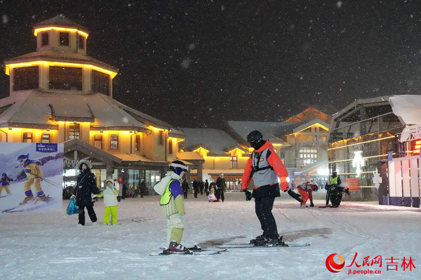 在長白山滑雪度假區(qū)，小朋友在教練的指導(dǎo)下穿上雪板。人民網(wǎng)記者 李洋攝