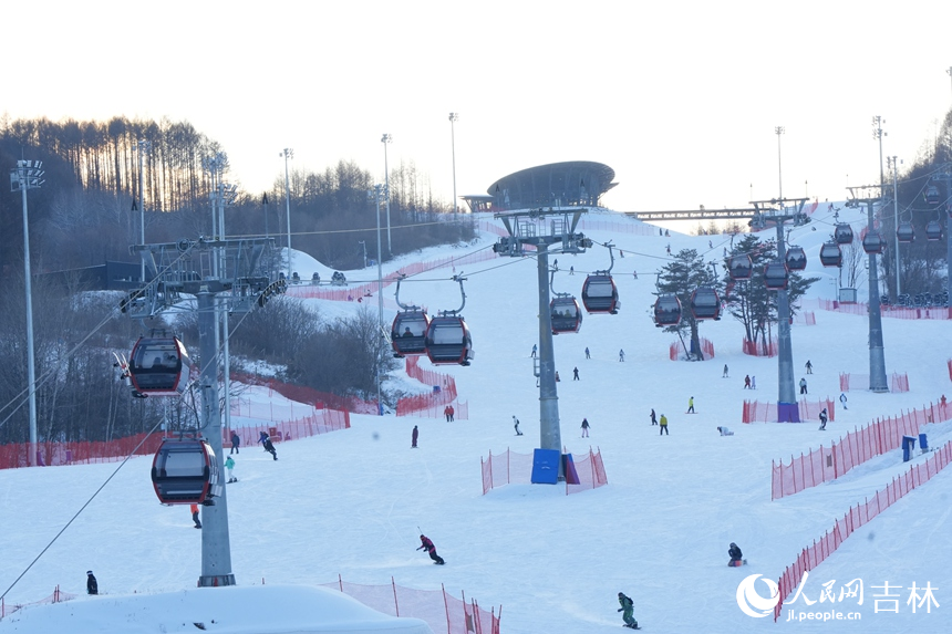 在吉林通化萬峰滑雪度假區(qū)，雪友們在雪道上享受冰雪樂趣。（12月21日攝）。人民網(wǎng)記者 李洋攝