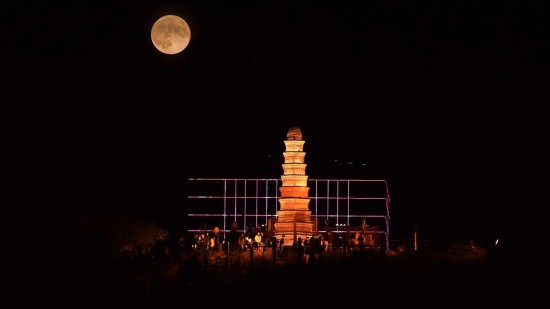 9月29日晚，中秋圓月升起，與新疆烏魯木齊地標建筑紅山塔重疊（二次曝光）。人民網(wǎng) 李欣洋攝